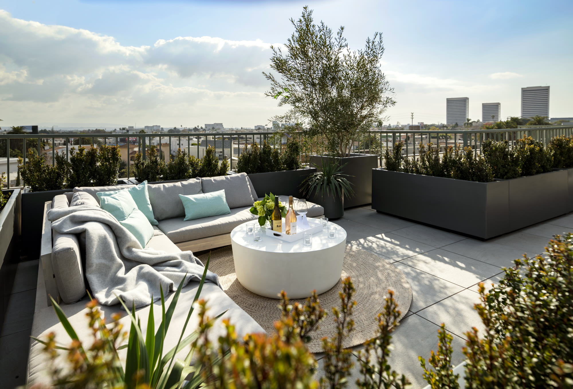 Rooftop sundeck with lounge seating and Los Angeles skyline views at Lumiere at Malcolm