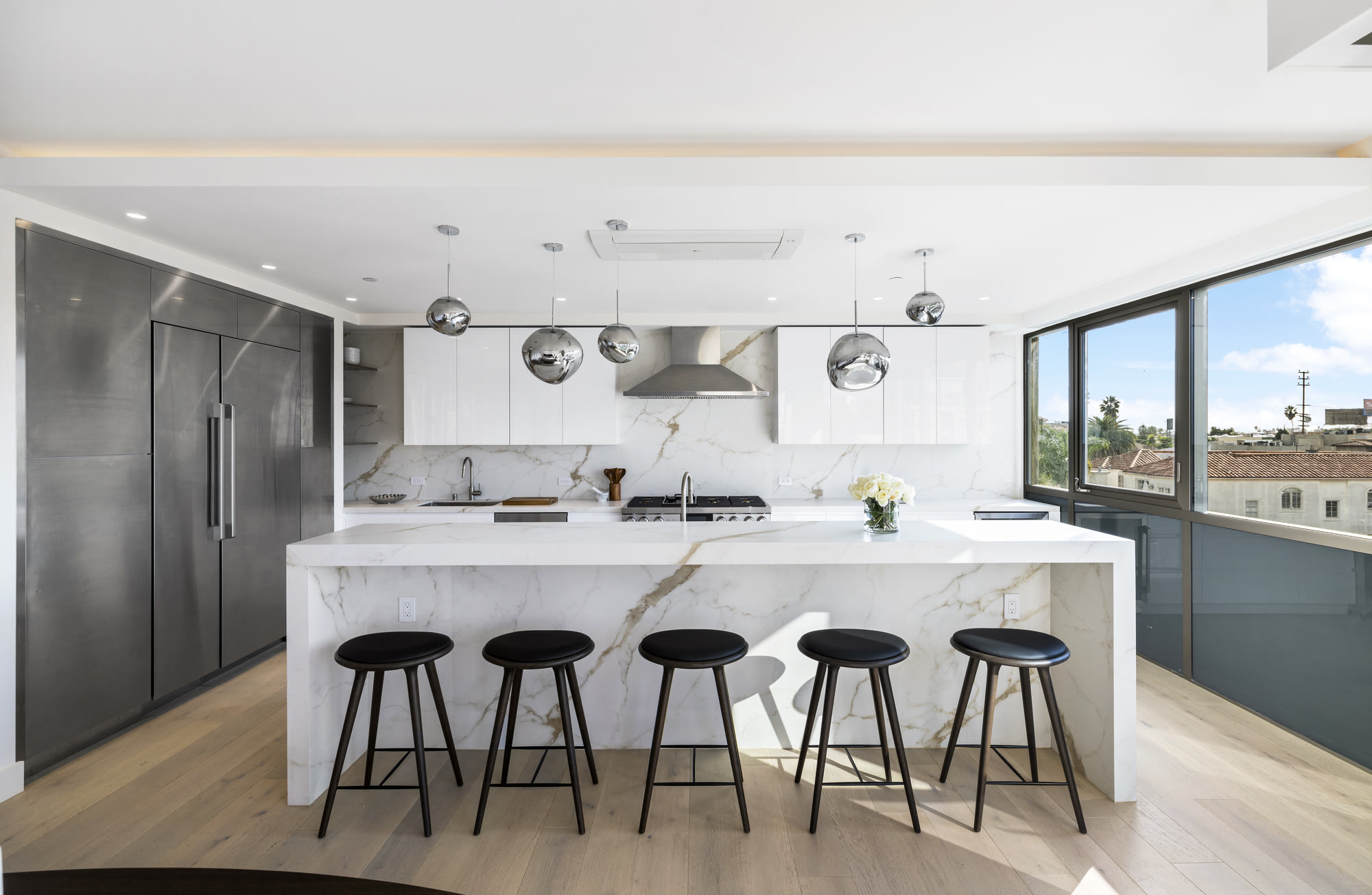 Chef's kitchen with Calacatta marble island and city view at Lumiere at Malcolm